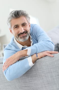 45-year-old man relaxing in sofa at home