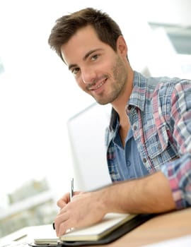 Smiling office worker sitting at desk