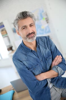 Portrait of smiling mature teacher in class