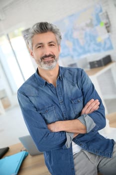 Portrait of smiling mature teacher in class