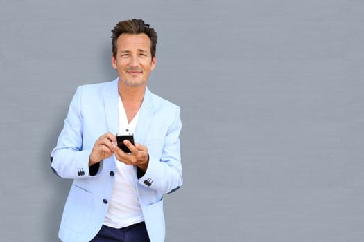 Handsome mature man using smartphone, isolated