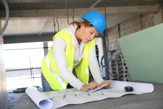 Woman architect on building site using tablet