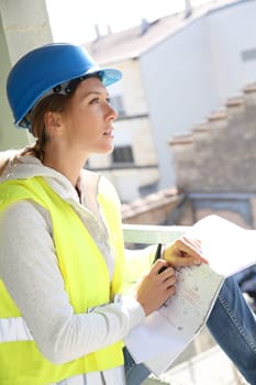 Woman engineer on building site checking construction