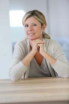 Portrait of smiling confident woman sitting at table