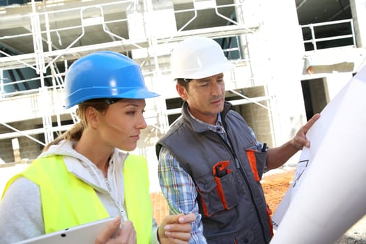 Engineers on building site checking plans