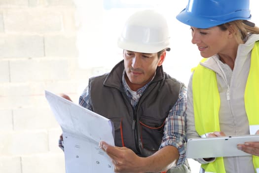 Engineers on building site checking plans