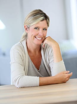 Portrait of smiling confident woman sitting at table
