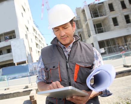 Entrepreneur on building site using tablet