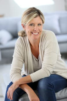 Smiling attractive woman sitting in sofa