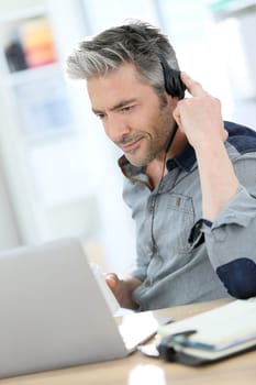 Mature man teleworking from home with laptop