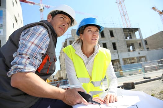 Engineers on building site checking plans