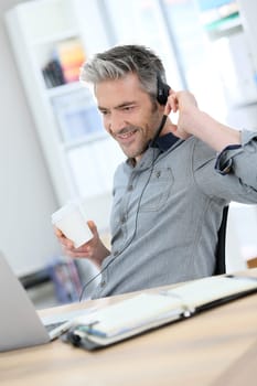 Mature man teleworking from home with laptop