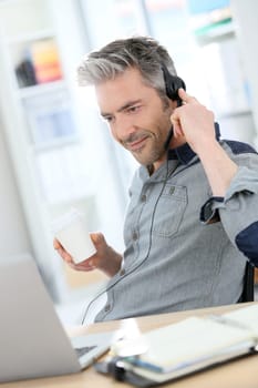 Mature man teleworking from home with laptop