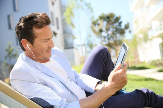 Man relaxing in resitential area with tablet