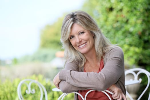 Portrait of smiling mature blond woman in garden