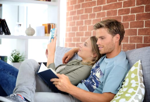 Young couple reading book in sofa