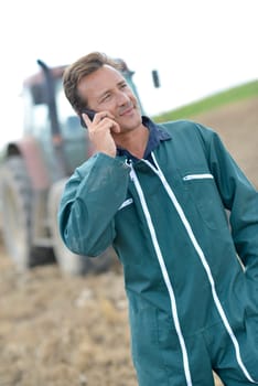 Farmer walking in field and talking on mobile phone