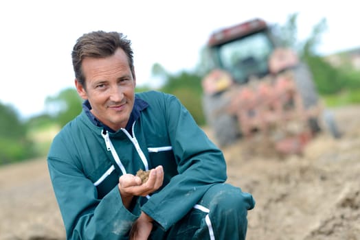 Farmer checking on cultivated ground quality