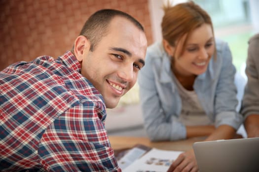Smiling guy in shared apartment with roommates