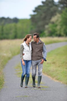 Cheerful 40-year-old couple walking in countryside