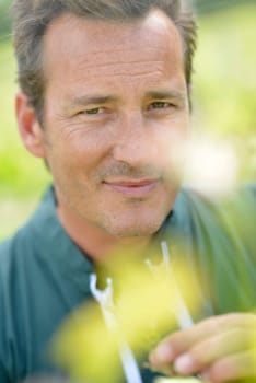 Winegrower in vineyard checking on grapes