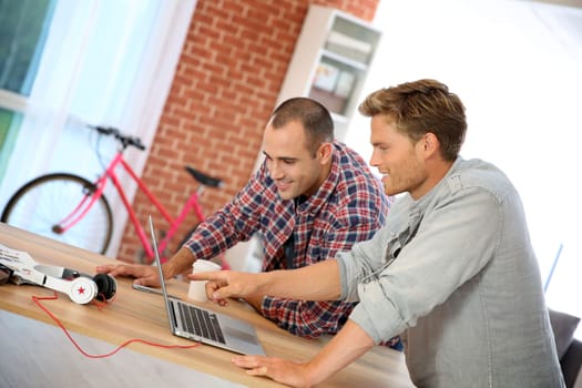 Young men studying in front of laptop