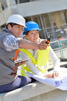 Engineers on building site checking plans