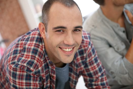 Smiling guy in shared apartment with roommates