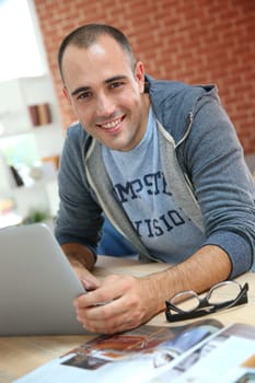 Smiling man at home websurfing on net