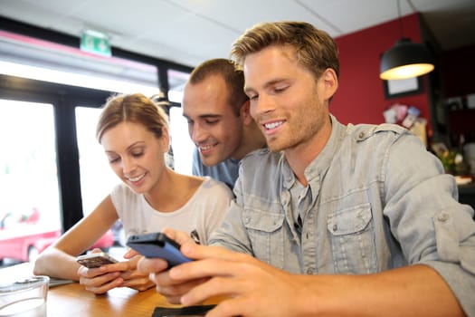 Young people in campus lounge connected on smartphone