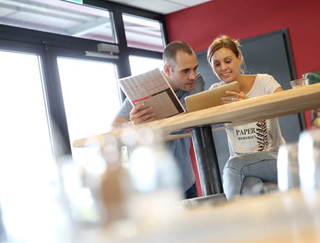 Friends in bar websurfing on tablet