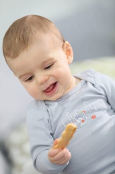 Portrait of cute baby boy eating child biscuit