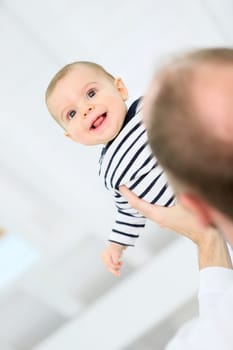 Daddy holding baby boy up in the air