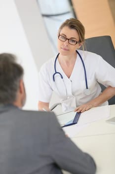 Doctor meeting with patient in hospital office
