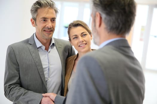 Adviser giving handshake to clients