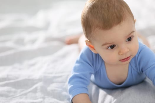 8-month-old baby boy laying on bed