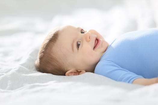 8-month-old baby boy laying on bed