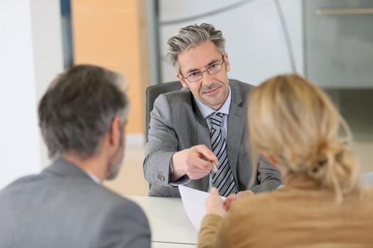 Mature couple signing contract in lawyer's office