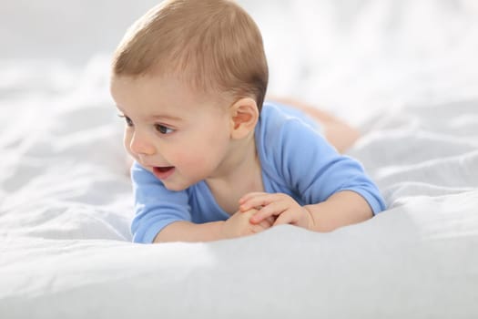 8-month-old baby boy laying on bed
