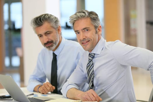 Businessmen working in office with laptop