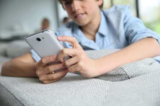 Teenage boy using smartphone at home