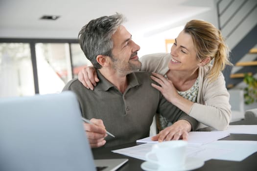 Couple calculating financial savings on internet
