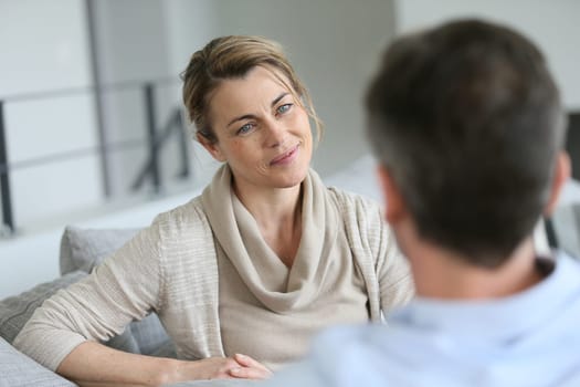 Couple at home sitting in sofa and having a talk
