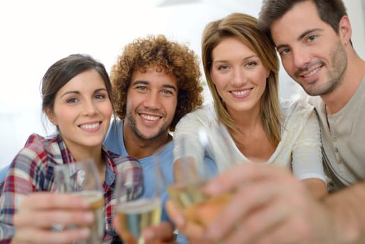 Closeup of friends cheering with glass of wine