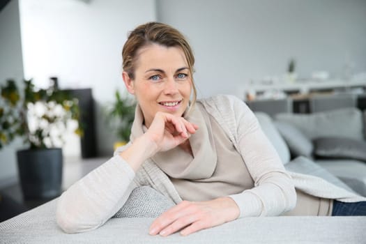 Blond middle-aged woman relaxing in living-room