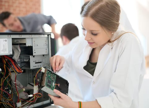Student girl in technology fixing computer hard drive