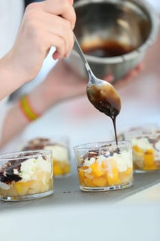 Closeup of chocolate being poured on dessert