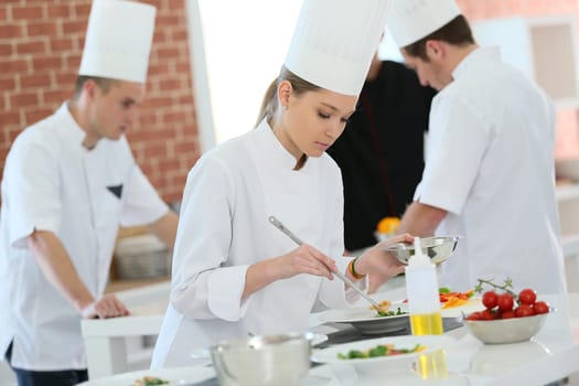 Girl in cooking training class preparing dish