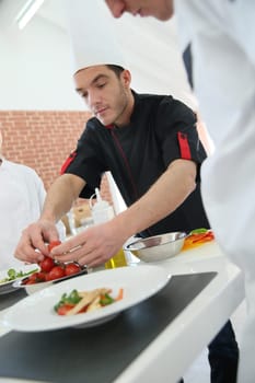 Chef training students in restaurant kitchen