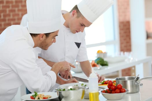 Chef training students in restaurant kitchen